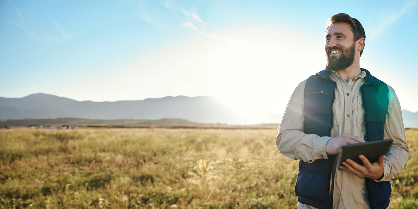 Farmer in a field holding a tablet