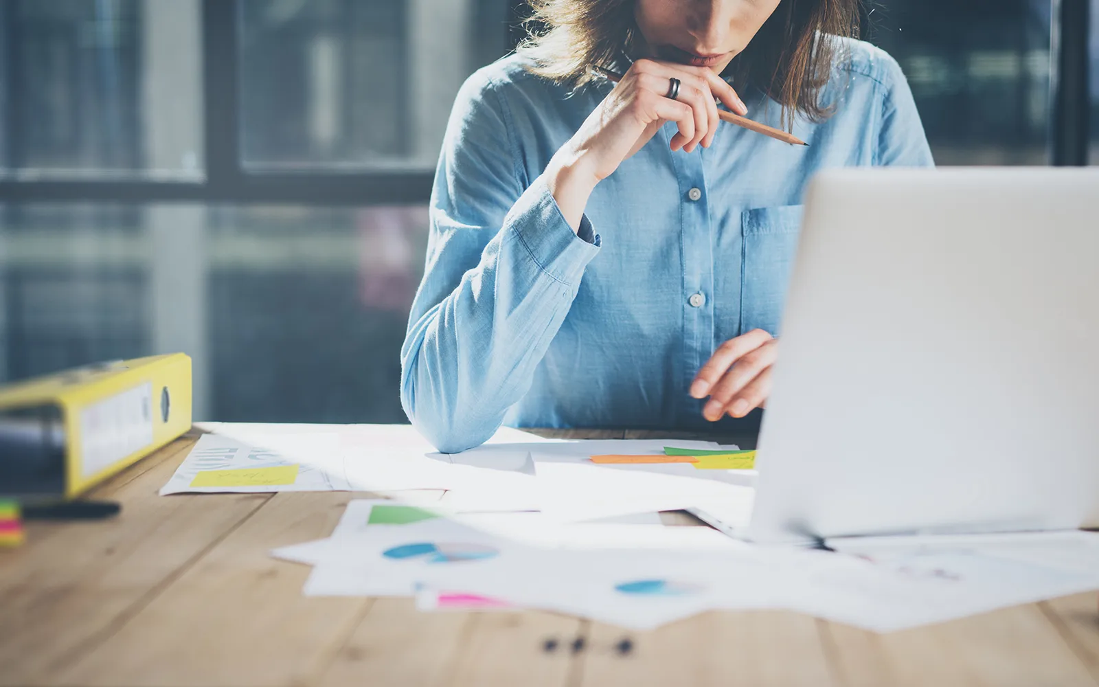 A person working at a table covered in paperwork 