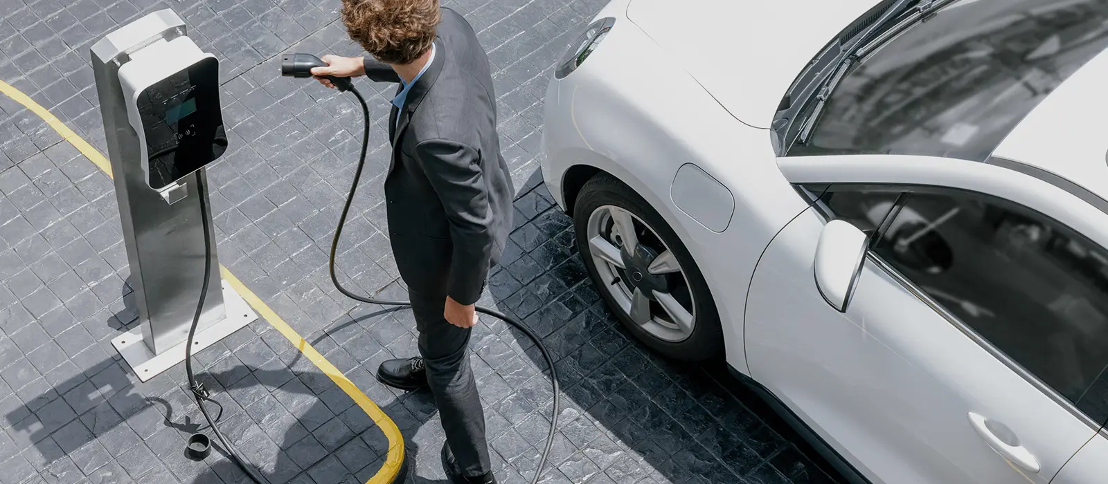 Business person charging electric vehicle