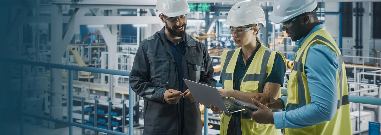 Manufacturing workers reviewing documents on a laptop