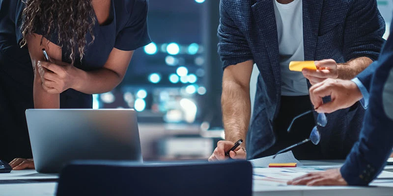 Two professionals working together in front of a desk.