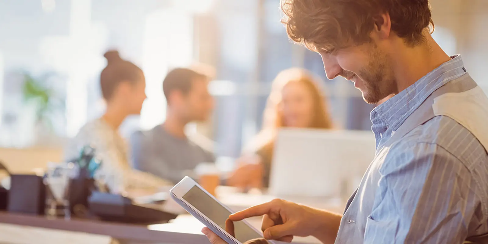 Man looking down at a tablet and smiling