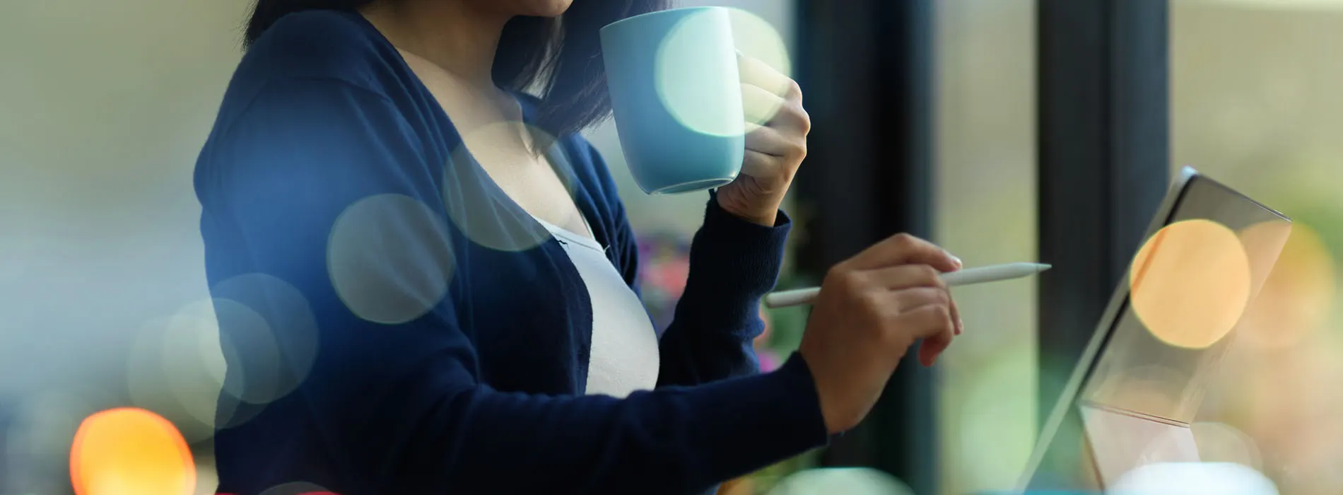 business owner drinking coffee while working on tablet