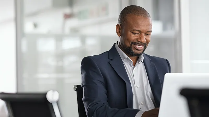 Homme d'affaires souriant travaillant à l'ordinateur