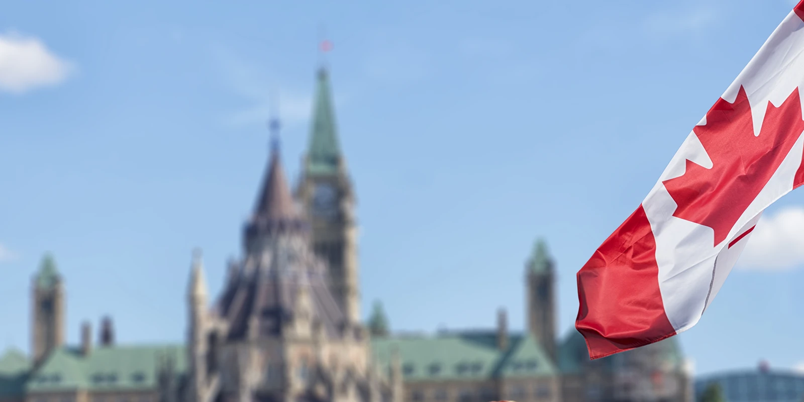 Canadian flag with the Canadian parliament in the background