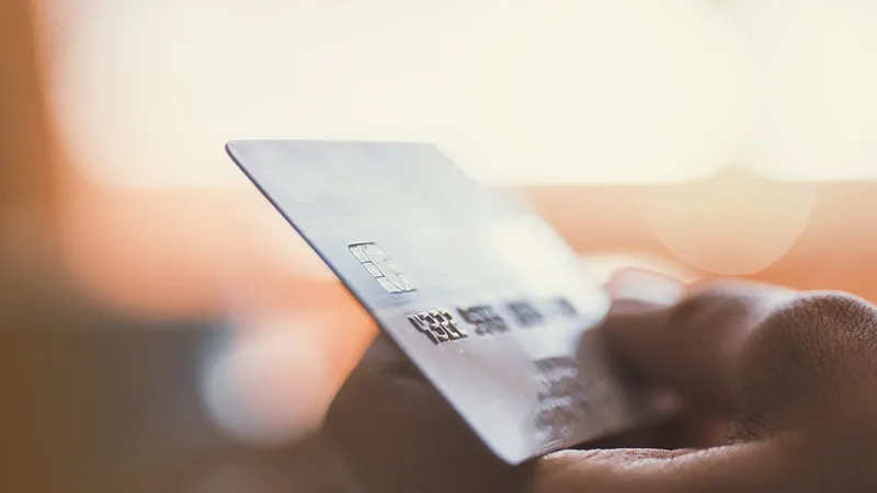 Close up of a hand holding a credit card